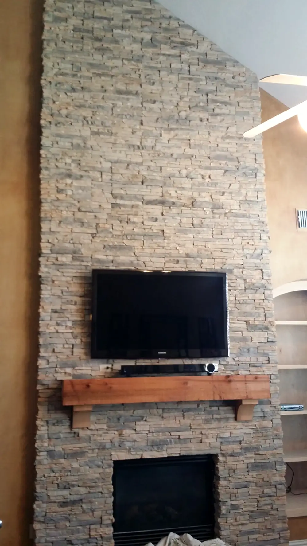 Stacked-stone fireplace wall running up a vaulted ceiling