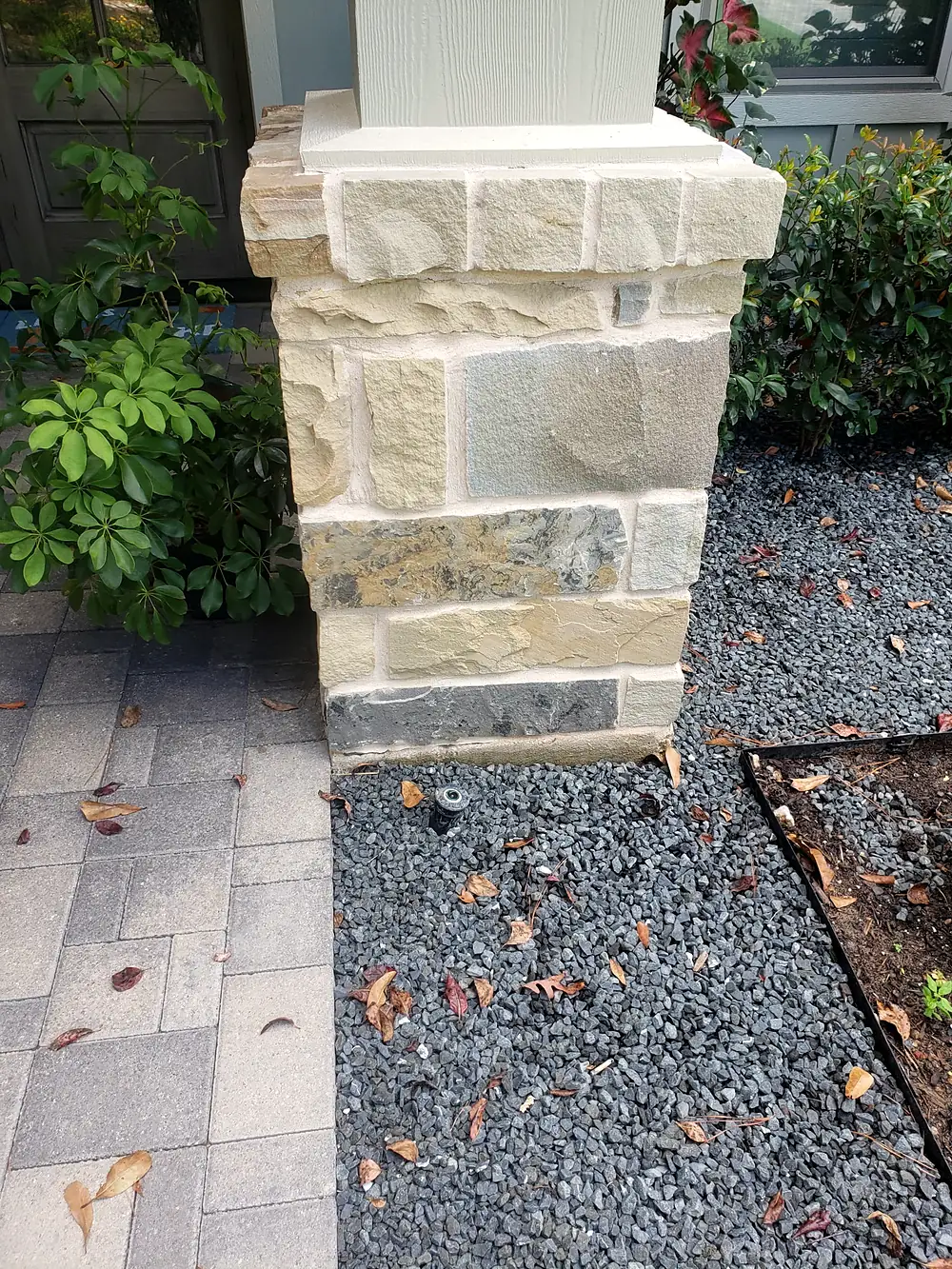 A porch column wrapped in squared natural stone